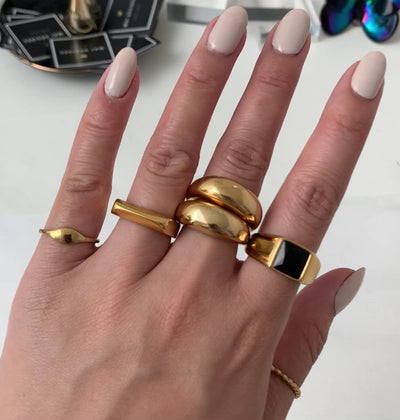 gold rings waterproof jewelry. the drew ring worn on pinky. The Carter ring worn on ring finger, the capri ring double stacked worn on middle finger. The Chicago black sight ring worn on pointer finger, and the Jaina dainty gold beaded ring worn on thumb., waterproof jewelry