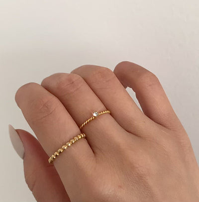 Jaina thin gold beaded ring paired with thin twist solitaire ring. Waterproof jewelry